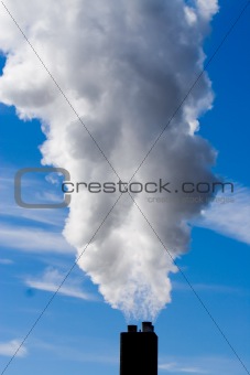 chimney billowing white smoke into blue sky