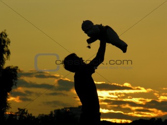 father with baby on sunset