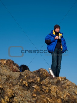 man thinking on the mountain top with blue sky