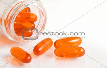 Fish oils pills and bottle closeup