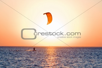 Silhouette of a kitesurfer on a gulf on a sunset