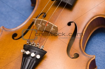 musical instrument - detail of old violin on blue background
