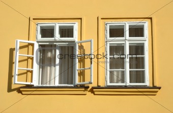 Two windows on yellow wall