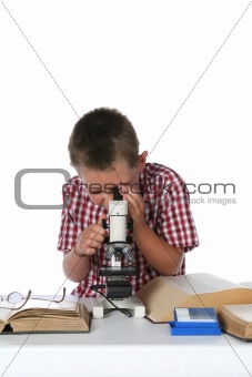 child with glasses on the book looking through his microscope