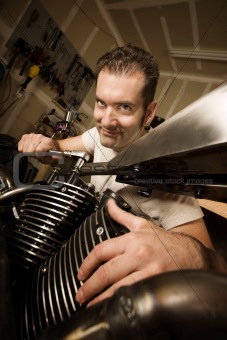 Man in garage working on motocycle