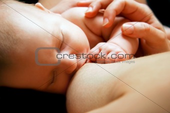 close up of newborn baby near breast
