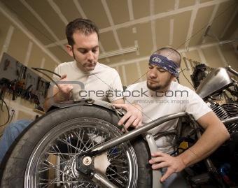 Two Motorcycle Mechanics Placing a Fender