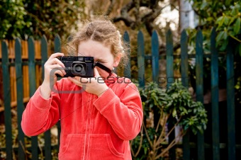 young girl in red jacket with camera
