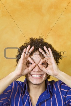 man smiling with hand over eyes