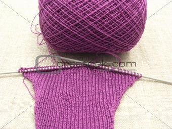 Pink colored knitting on a  beige background