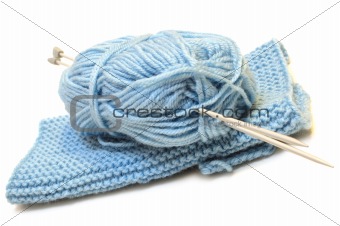 Two knitting needles, woollen yarn clew and knitting cloth.