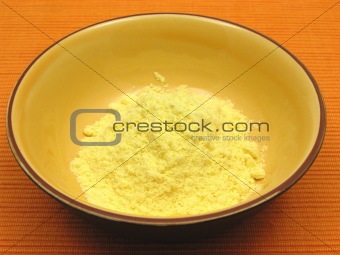 Cornmeal  in a bowl of ceramic on an orange background