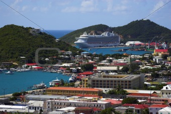 Tropical town - tropical island with a small red-roof town with the background of the large cruise ship