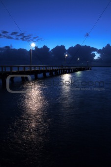 Jetty at night with lights on the water