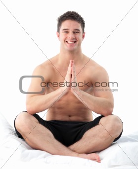 Man meditating on bed