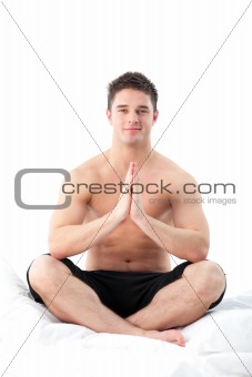 Man meditating on bed