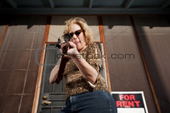 Woman on front porch with rifle