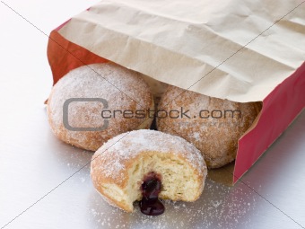 Bag Of Raspberry Jam Doughnuts With A Bite Taken
