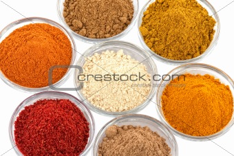 several indian spices in glass bowls