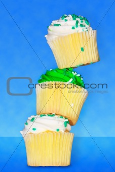 Three delicious vanilla cupcakes with buttercream frosting stack