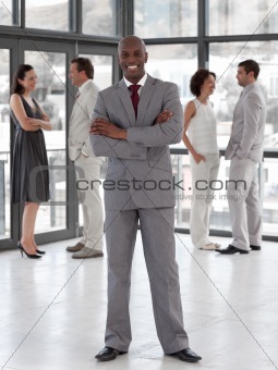 Potrait of a Business man standing smiling in front of team 