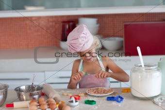 Blond little girl baking in the kitchen