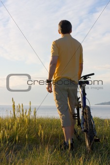 Man with bicycle at the sea