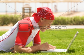 Sport man & laptop on the beach