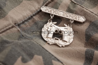 Pistol Expert War Medal on a Camouflage Background.