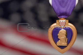 Purple Heart Against a Blurry Americal Flag.