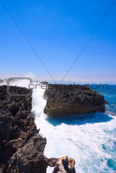 Waves crushing against rocky cliff