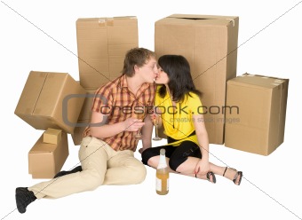 Girl and the guy drink champagne near boxes