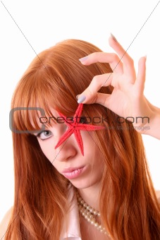 Young redhead woman with starfish in hand isolated