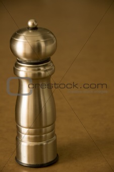 Pepper mill sitting on a bworn kitchen counter