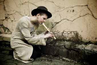 Young girl in a hat playing flute
