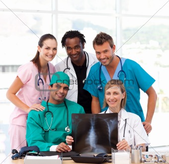 Medical team examining an X-ray and smiling at the camera