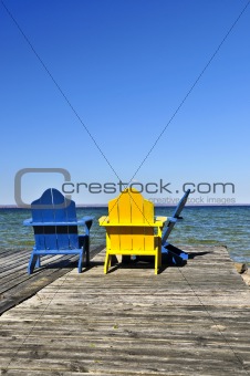 Chairs on wooden dock at lake