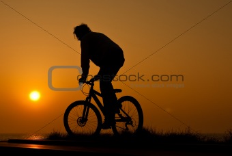 silhouet of a young adult riding a bike