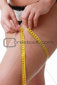 A little bit fat young woman mesuring her body