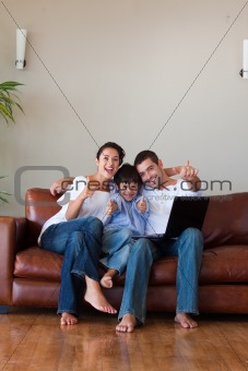 Parents and kid having fun with a laptop and copy-space