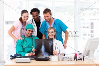 Nurse, doctors and surgeon examining an X-ray