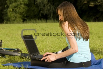 female student working with laptop outdoor