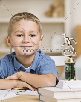 Boy Sitting in Front of Soccer Trophy