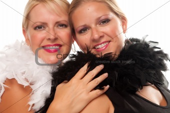 Portrait of Two Blonde Haired Smiling Girls with Feather Boas Isolated on a White Background.