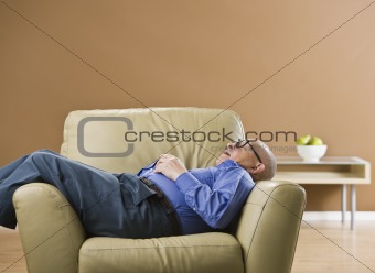 Senior man sleeping on chair.