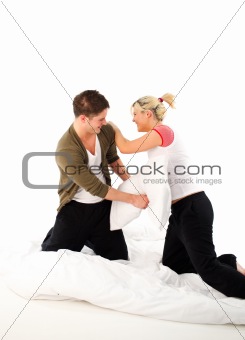 Couple having fighting in bed with pillows