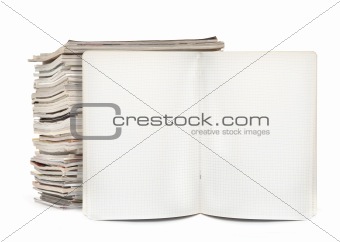 squared exercise book and magazines