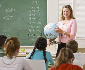 Teacher explaining globe to students