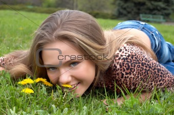 pretty girl smells dandelion on the green meadow