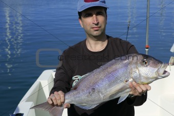 Fisherman showing proud catch saltwater fish